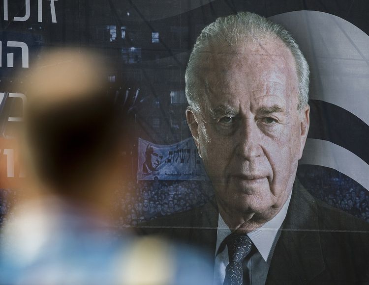 A man stands in front of a huge portrait of late Israeli prime minister Yitzhak Rabin, ahead of a memorial rally marking the 20th anniversary of Rabin's assassination in the Israeli city of Tel Aviv, on October 29, 2015