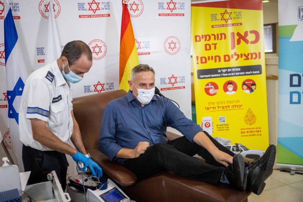 Israel's Health Minister Nitzan Horowitz donates blood at a Magen David Adom blood donation center in Jerusalem on October 25, 2021.