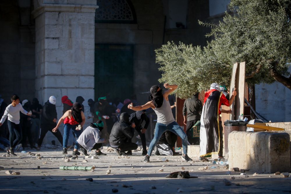 Des manifestants palestiniens lancent des pierres en direction des forces de sécurité israéliennes lors d'affrontements pendant le mois sacré du Ramadan dans l'enceinte de la mosquée Al-Aqsa, dans la vieille ville de Jérusalem, le 15 avril 2022.