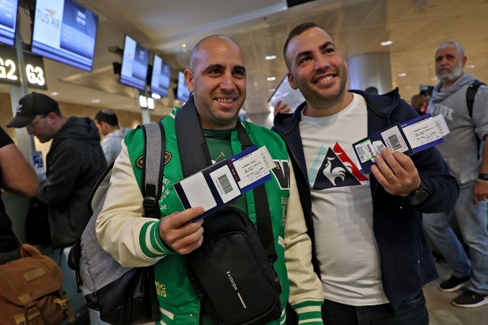 Football fans show their Israeli passports and air tickets as they prepare to board a TUS Air flight from Tel Aviv's Ben Gurion airport to Doha, Qatar, to attend the World Cup 2022, on November 20, 2022.