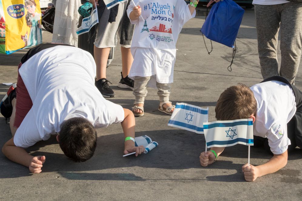 Des nouveaux immigrants venus de France embrassent le tarmac de l'aéroport Ben Gourion lors de leur arrivée en Israël, le 10 juillet 2017