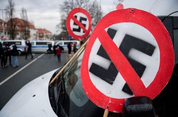 A prohibition sign with a swastika is seen on the hood of a car during a demonstration near the fairground in Dresden, Germany, on April 10, 2021.