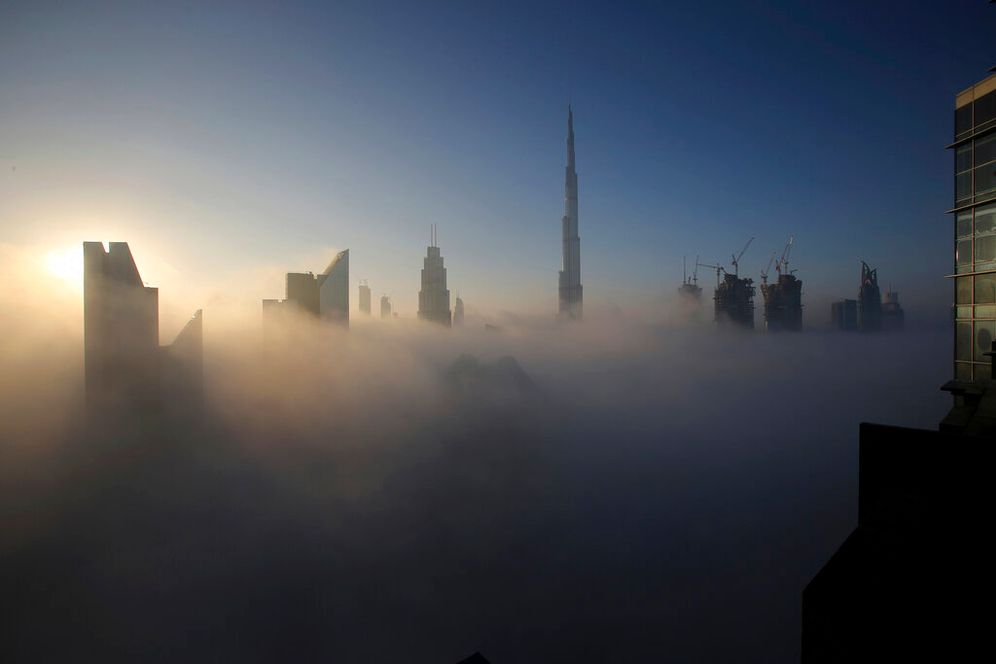 The sun rises over the city skyline with the Burj Khalifa in Dubai, the United Arab Emirates, on December 31, 2016.
