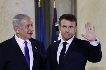 French President Emmanuel Macron (R) welcomes Israel's Prime Minister Benjamin Netanyahu at the Presidential Elysee Palace in Paris, France.