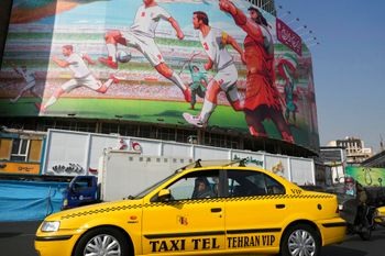 A state-sponsored mural showing a painting of national soccer players and legendary heroes in Persian mythology hangs on a building, in downtown Tehran, Iran.