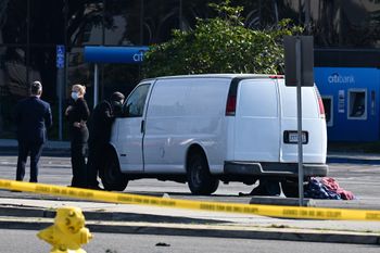 A police officer in Torrance, California, peers into the van of the gunman who killed 10 in Monterey Park nearby
