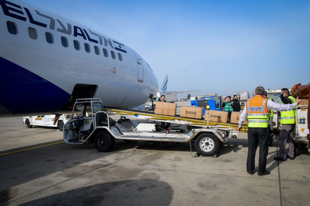 Archive - Des travailleurs chargent des colis d'aide humanitaire israélienne pour l'Ukraine à bord d'un avion El Al, à l'aéroport Ben Gourion de Tel Aviv