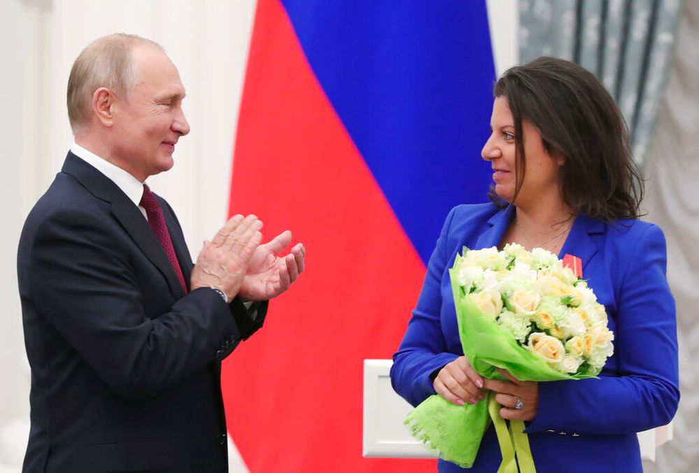 Russian President Vladimir Putin applauds to Margarita Simonyan (R), the head of the Russian television channel RT after awarding her with the Order of Alexander Nevsky during a ceremony in the Kremlin in Moscow, Russia.