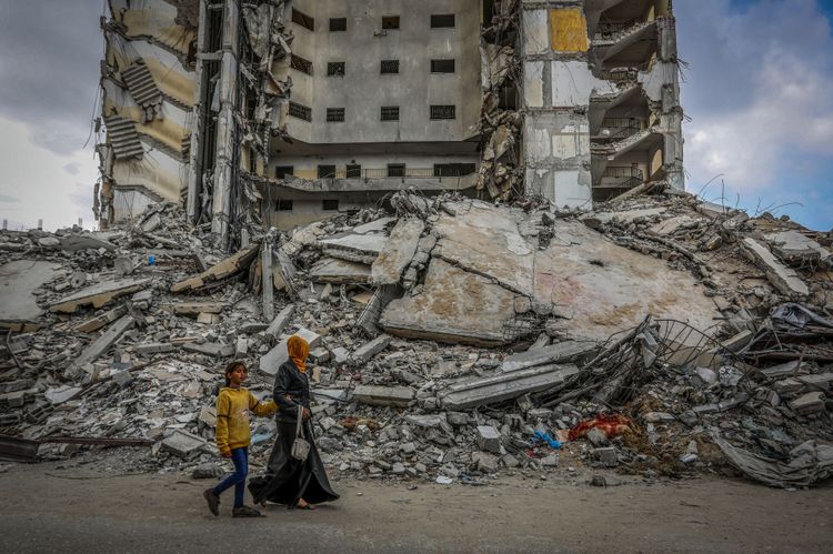 Palestinians at the site of a destroyed building from an Israeli air strike in Rafah, in the southern Gaza Strip,