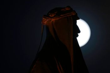 The full moon rises over the Statue of King Faisal I in central Baghdad, Iraq, on July 13, 2022.
