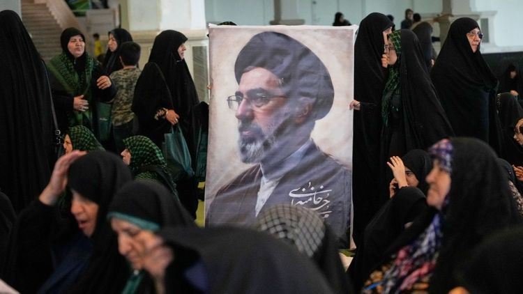 Women gather around a portrait of Iran's Supreme Leader, Ayatollah Mojtaba Khamenei, during a ceremony honoring the armed forces and those killed in the war with Israel and the U.S. at the Imam Khomeini Grand Mosque in Tehran, Iran, Sunday, May 24, 2026. 
