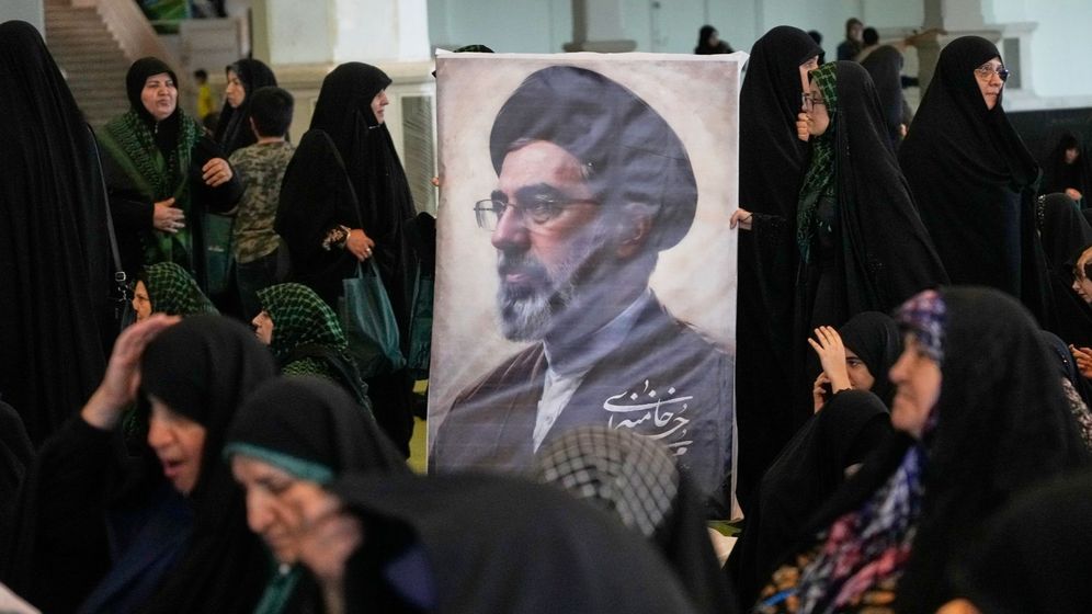 Women gather around a portrait of Iran's Supreme Leader, Ayatollah Mojtaba Khamenei, during a ceremony honoring the armed forces and those killed in the war with Israel and the U.S. at the Imam Khomeini Grand Mosque in Tehran, Iran, Sunday, May 24, 2026. 
