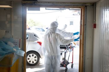 Israeli healthcare workers wearing protective clothing at the coronavirus ward of the Sha'are Zedek hospital in Jerusalem on February 09, 2022.