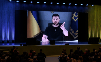 Le président ukrainien Volodymyr Zelensky apparaît sur un écran géant alors qu'il prononce un discours au début d'une conférence internationale de deux jours sur la reconstruction de l'Ukraine, à Lugano, le 4 juillet 2022.
