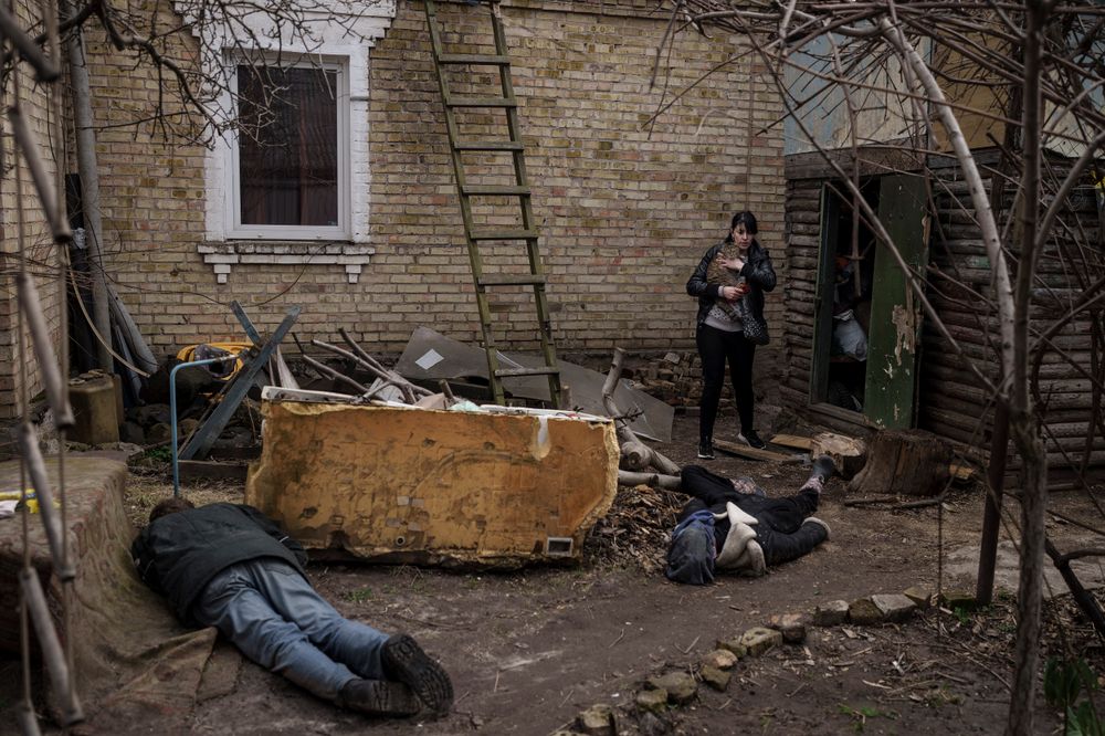 Une femme près des corps de son mari, de son frère et d'un autre homme, tués devant chez elle à Boutcha, à la périphérie de Kiev, en Ukraine, le 4 avril 2022