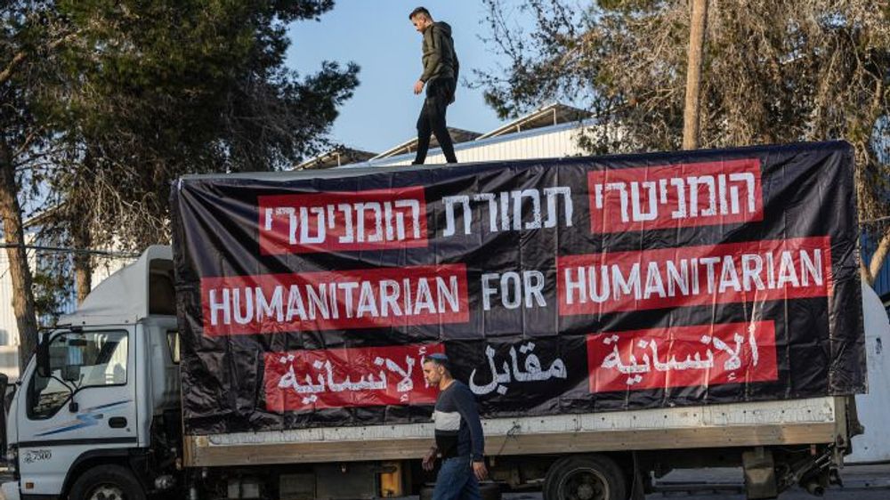 Parents of Israeli soldiers who are operating in the Gaza Strip and activists protest against trucks of humanitarian aid going into Gaza Strip, near the Kerem Shalom crossing in southern Israel.
