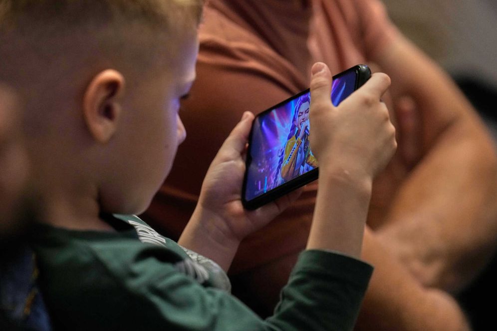 AP Photo/Gregorio Borgia A child watches on a phone KPop Demon Hunters series as Pope Leo XIV leads a vigil for peace inside St. Peter's Basilica at the Vatican, Saturday, April 11, 2026.