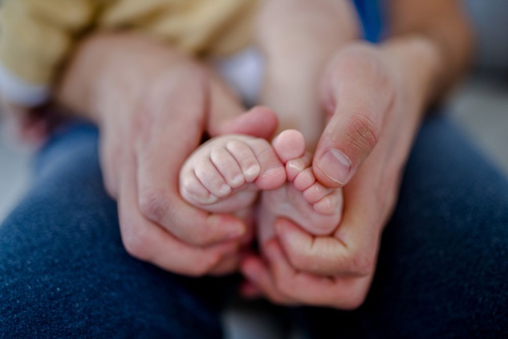 A father holds the legs of his baby girl in Jerusalem, December 30, 2020.