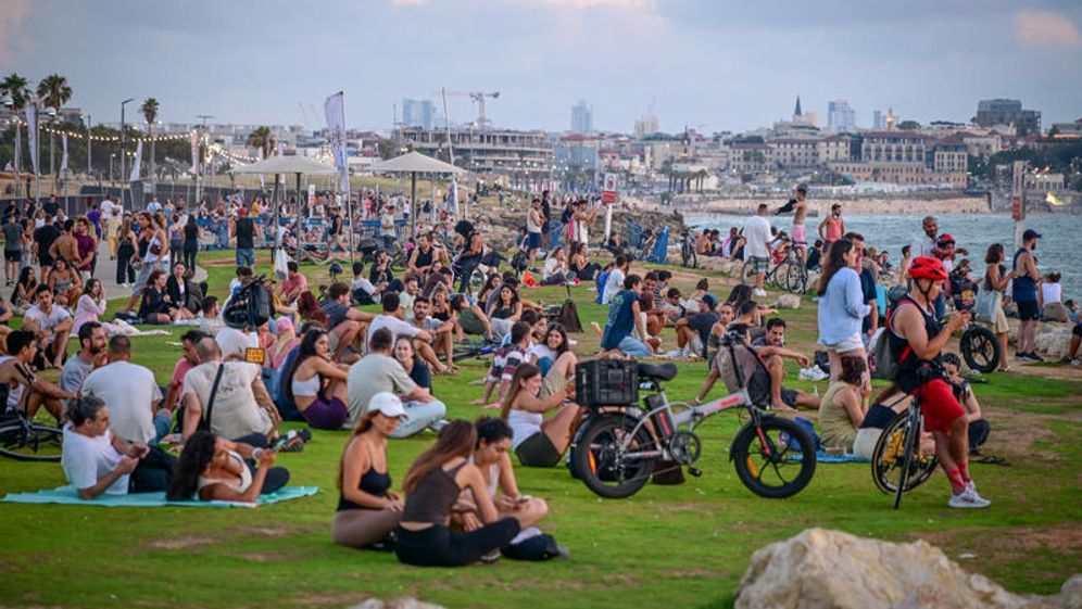 אבשלום ששוני/פלאש 90 עוברי אורח צופים בשקיעה בטיילת בתל אביב