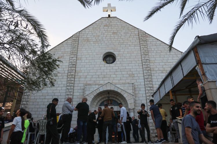 File photo of Palestinians standing outside after attending mass for late Pope Francis at the Holy Family Church in Gaza City on April 21, 2025