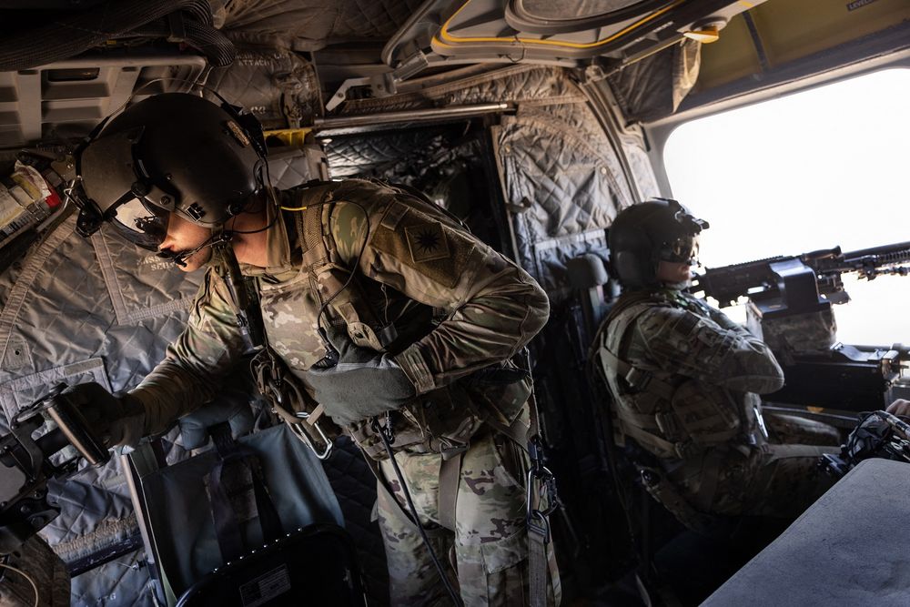 US Army CH-47 Chinook helicopter gunners scan the desert while transporting troops on May 26, 2021 over northeastern Syria.
