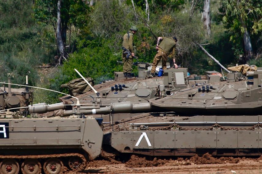 Israeli soldiers work next to their tanks near the Israel Gaza border, Israel, Tuesday, March 26, 2019.