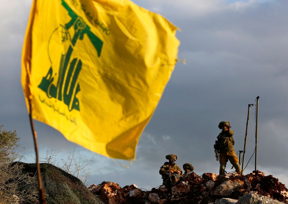 Des soldats israéliens montent la garde à côté de caméras devant un drapeau du Hezbollah, près du village de Mays al-Jabal, à la frontière sud du Liban.