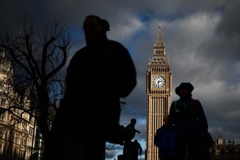 مشاة أمام برج إليزابيث، المعروف باسم جرس ساعة "بيج بن"، في قصر وستمنستر، مقر مجلسي البرلمان، في وسط لندن، عند غروب الشمس، في 6 يناير 2025.