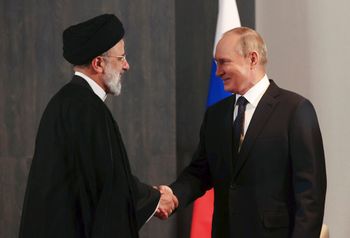 Russian President Vladimir Putin (R), and Iranian President Ebrahim Raisi (L) shake hands during their meeting in Samarkand, Uzbekistan.
