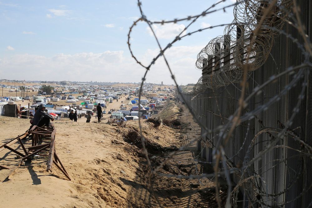 Displaced Palestinians at the Border fence between Egypt and Gaza, in Rafah.