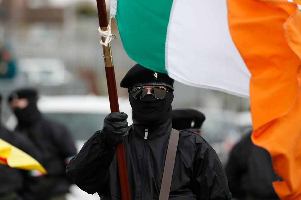 Masked Republican protesters opposed to the Good Friday Agreement hold Irish flags as they take part in a parade in Londonderry, Northern Ireland.