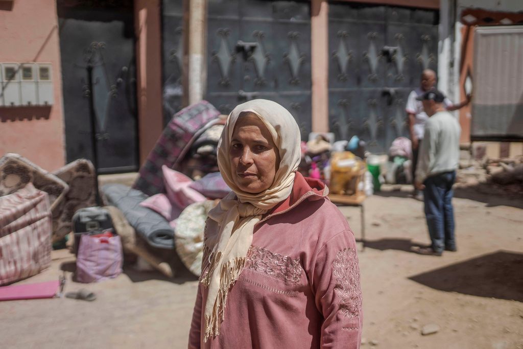 امرأة تراقب السكان وهم يجمعون ممتلكاتهم بعد أن تضررت منازلهم بسبب الزلزال في أمزميز