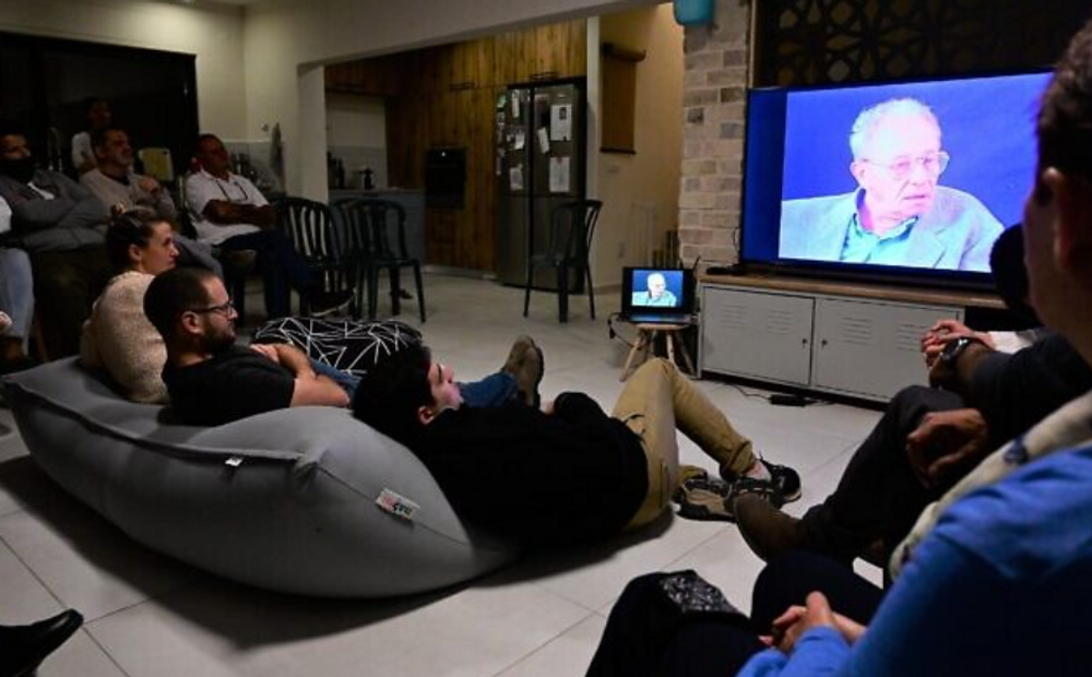 Des Israéliens regardent le témoignage d'un survivant de la Shoah lors d'une réunion dans le cadre du projet 'Zikaron Basalon', à la veille de la journée du Souvenir de la Shoah, au Moshav Kidmat Tzvi, le 7 avril 2021.