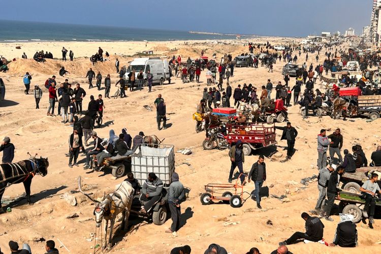 Palestinians wait for humanitarian aid on a beachfront in Gaza City, Gaza Strip