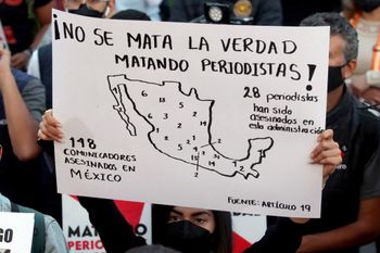 A journalist holds a poster that reads "The killing of periodists doesn't kill the truth" during a demonstration against violence against journalists, especially for the murders of journalists Margarito Martinez and Lourdes Maldonado in Tijuana last week, in Guadalajara, Mexico, on January 25, 2022.