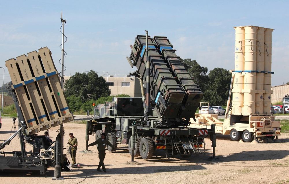 Israeli soldiers walk near Iron Dome (L) and Arrow-3 (R) missile defense systems at Hatzor Israeli Air Force Base in central Israel.