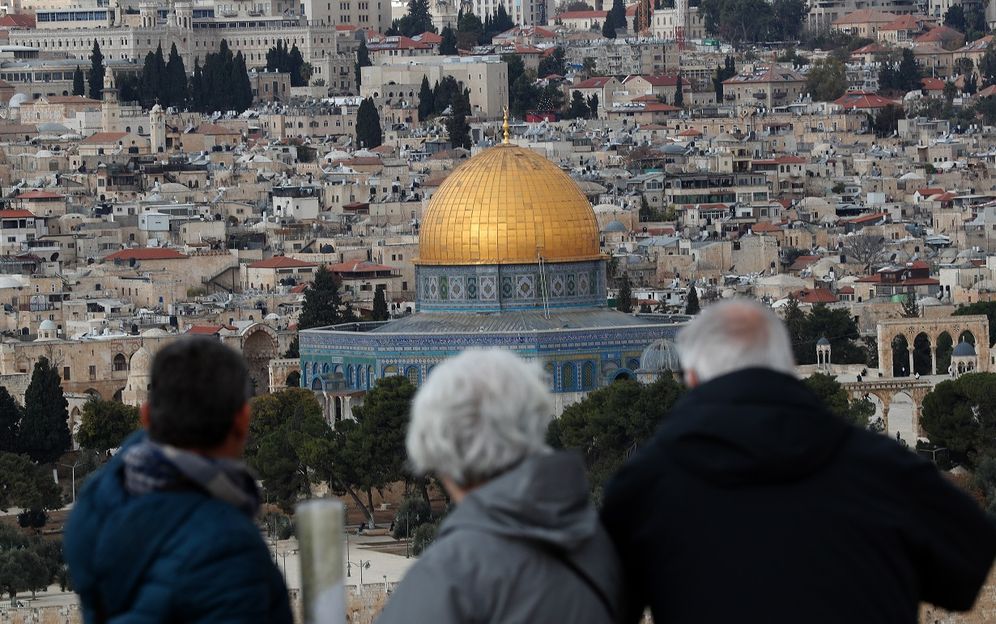 Tourists look at the Old City of Jerusalem and its Dome of the Rock mosque from the Mount of Olives on December 6, 2019