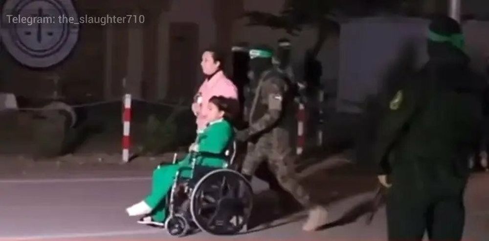 Yuval Engel, 11 ans, poussée en fauteuil roulant par un homme du Hamas lors de la remise des otages à la Croix-Rouge, le 27 novembre 2023