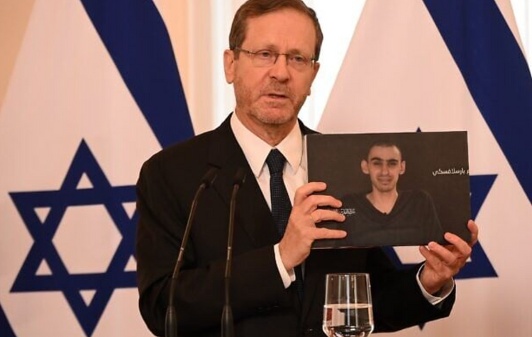 Le président Isaac Herzog brandit une photo de l'otage Rom Braslavski lors d'une conférence de presse conjointe avec le président letton Edgars Rinkevics, à Riga, en Lettonie, le 5 août 2025.