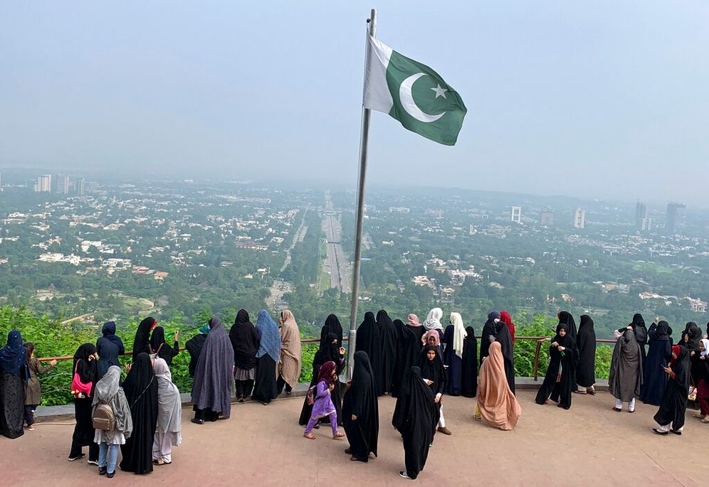 AP Photo/Rahmat Gul A Pakistani flag flies on a lookout as women take in the view of Islamabad, Pakistan.