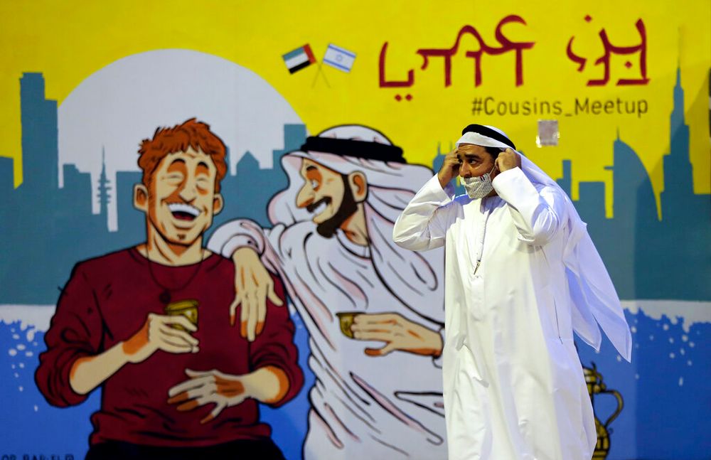 A man passes by a painting presenting Emirati and Israeli friendship at an exhibition in Dubai, United Arab Emirates.