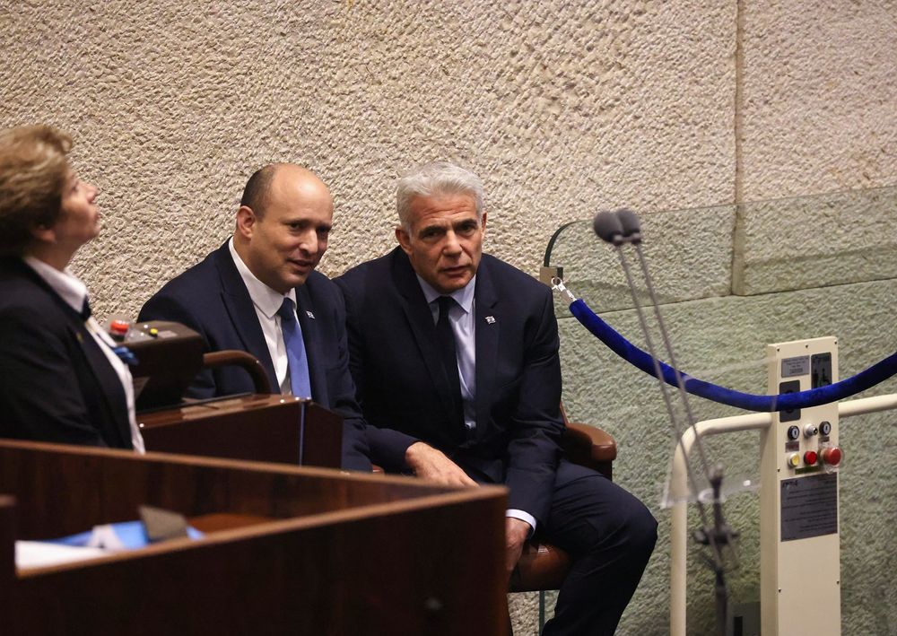 Israeli Prime Minister Naftali Bennett (C) and Foreign Minister Yair Lapid at Israel's parliament ahead of a session in Jerusalem, on June 27, 2022.