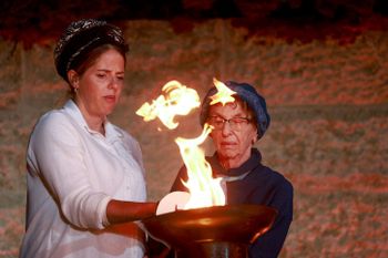 A Holocaust survivor and family member light the torch during a ceremony held at the Yad Vashem Holocaust Memorial Museum in Jerusalem, as Israel marks annual Holocaust Remembrance Day.