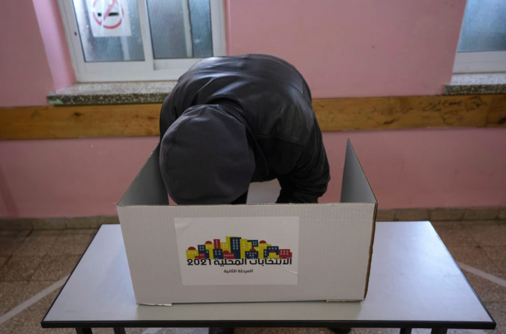 A voter prepares their ballot in a polling station during municipal elections in the city of Ramallah, on March 26, 2022.
