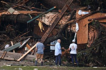 People look at debris on the banks of the Guadalupe River after a flash flood swept through the area Saturday, July 5, 2025, in Hunt, Texas