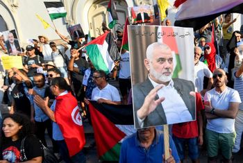 Des Tunisiens brandissent des drapeaux palestiniens et des portraits du chef du Hamas, Ismail Haniyeh, lors d'une manifestation dans la capitale Tunis, le 31 juillet 2024, pour dénoncer son assassinat