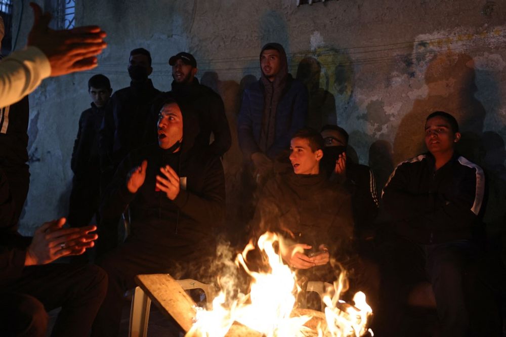 Palestinian residents of the east Jerusalem neighborhood of Sheikh Jarrah and supporters gather around a fire as they demonstrate on February 13, 2022.