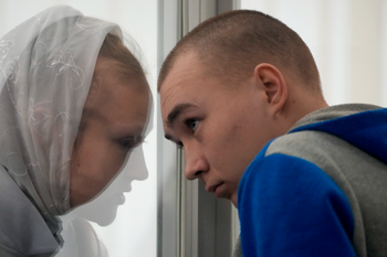 Russian Sgt. Vadim Shishimarin listens to his translator during a court hearing in Kyiv, Ukraine, May 23, 2022.