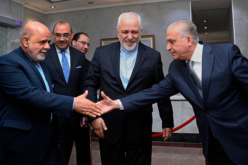 Iraq Foreign Minister Mohamed Alhakim, right, shakes hands with Iranian Ambassador to Iraq, Iraj Masjedi, left, during the visit of Iranian Foreign Minister Mohammad Javad Zarif, center, in Baghdad, Iraq, Sunday, March 10, 2019.