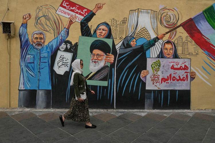 A woman walks past a pro-government mural in downtown Tehran, Iran, Sunday, May 17, 2026.